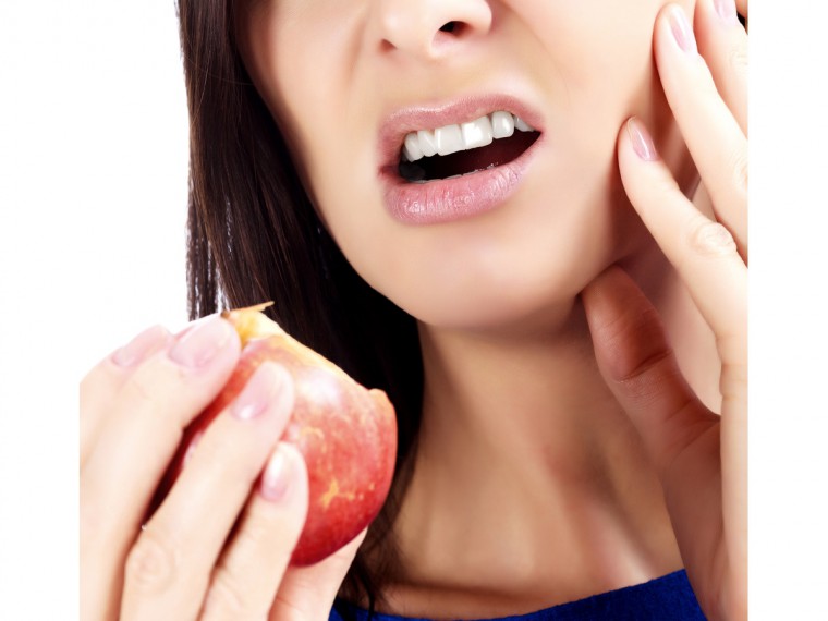 Frau-mit-Zahnschmerzen-Apfel-Mundhygiene-Zahnreinigung